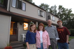 Family standing in front of house